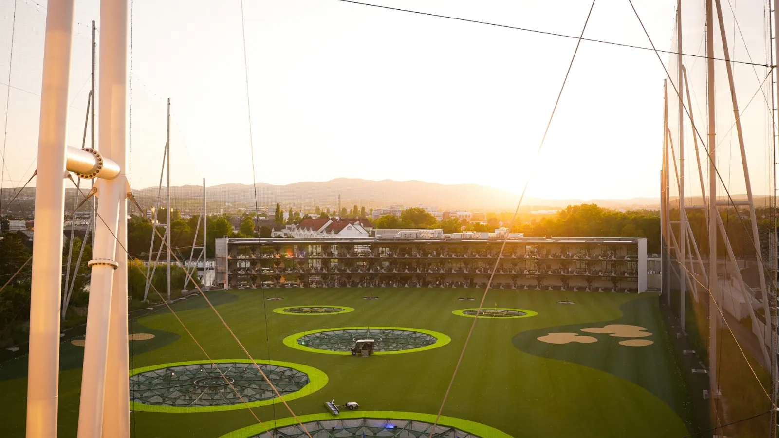 Blick über die Anlage von Topgolf Wien mit drei Etagen Bays