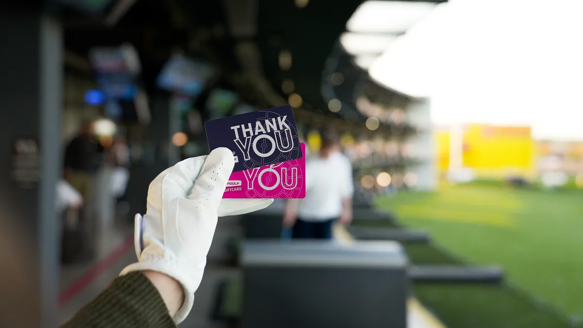 Zwei Topgolf Gutscheinkarten mit der Aufschrift Thank You, im Hintergrund die Bays